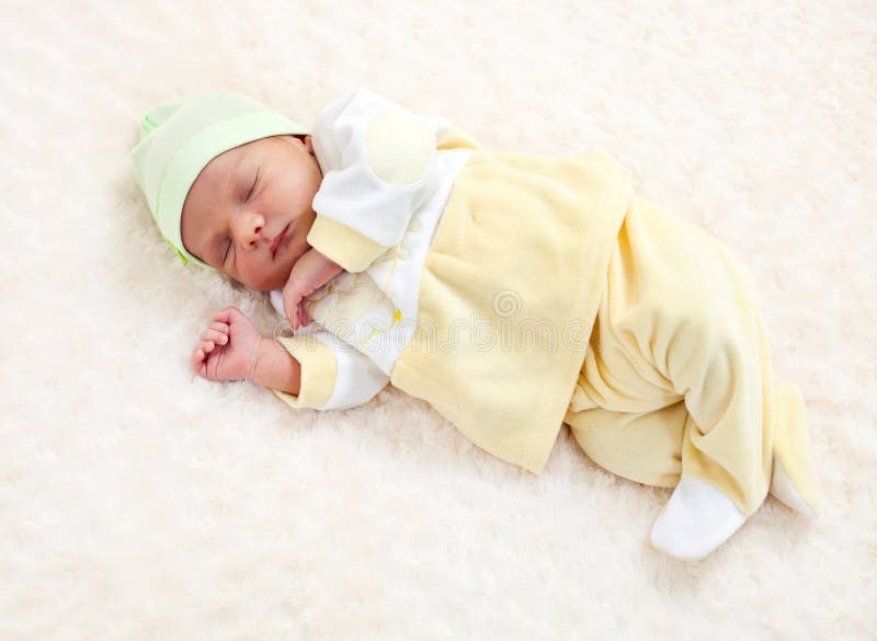 Peso Y Longitud Del Bebé Recién Nacido. Niño De Un Mes Durmiendo En Traje  Azul Acostado En Una Alfombra Esponjosa. Medida Del Tamaño De La Ropa De  Los Bebés. Desarrollo Del Crecimiento