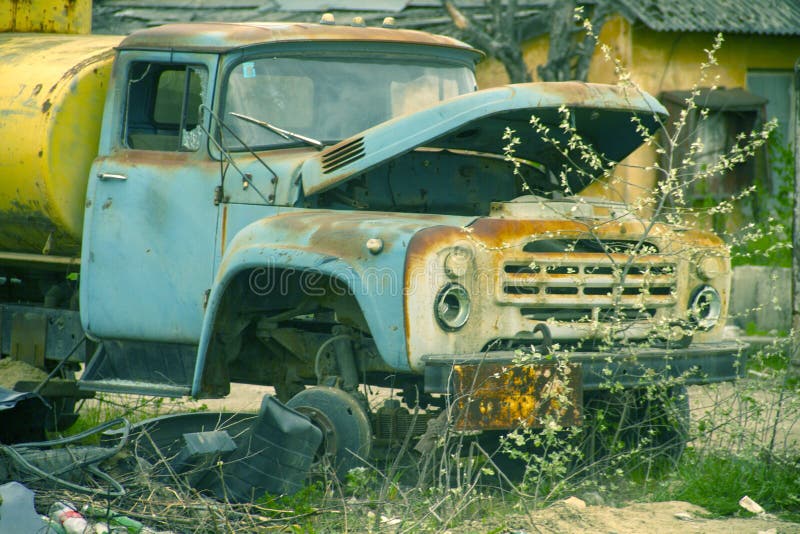 Un viejo tanque de gas abandonado con un tanque oxidado amarillo está estacionado sin ruedas imagen de archivo libre de regalías Un viejo tanque de gas abandonado con un tanque oxidado amarillo está estacionado sin ruedas imagen de archivo libre de regalías