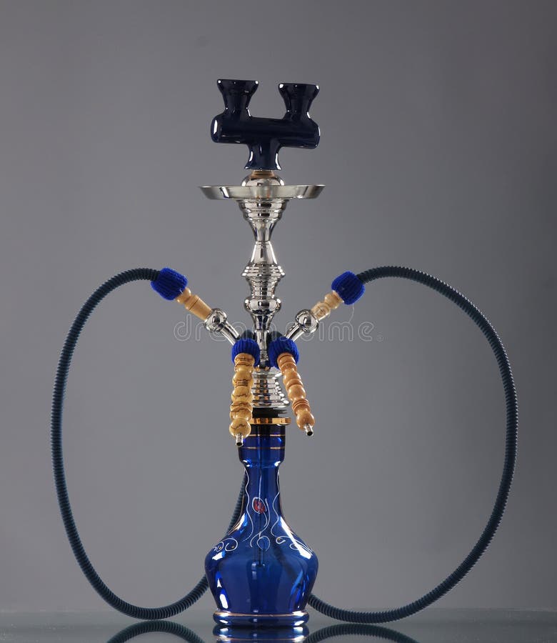 A beautiful old blue ceramic hookah. The image is taken in a studio on a grey background. A beautiful old blue ceramic hookah. The image is taken in a studio on a grey background.