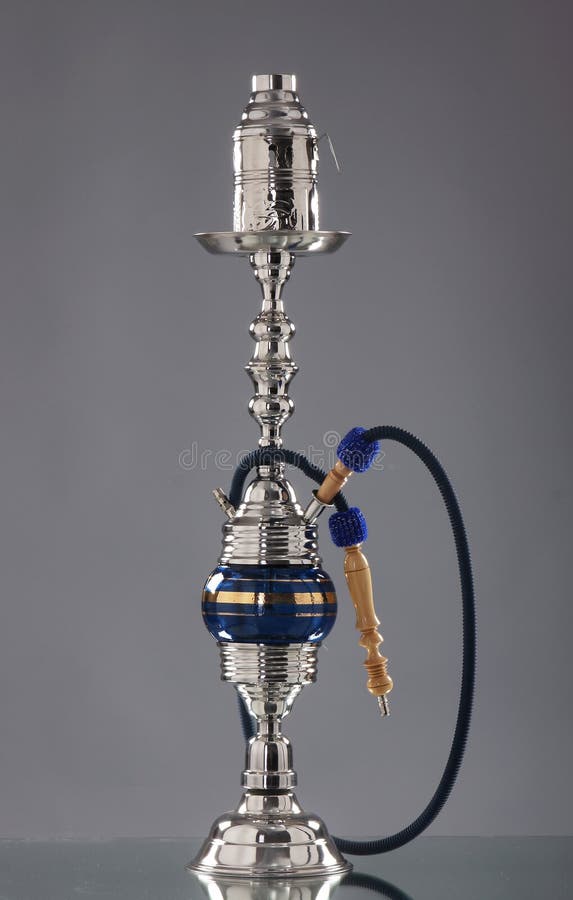 A beautiful old blue ceramic hookah. The image is taken in a studio on a grey background. A beautiful old blue ceramic hookah. The image is taken in a studio on a grey background.
