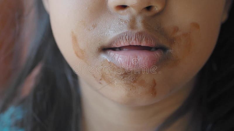 Un visage d'enfant recouvert de chocolat après avoir dégusté une gourmandise et une collation banque de vidéos