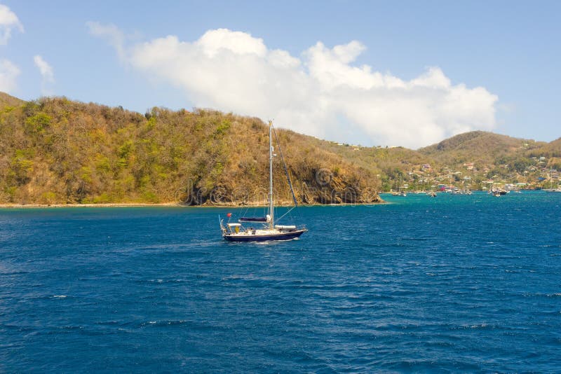 Un yacht che va in automobile nella baia di Ministero della marina, Bequia immagine stock Un yacht che va in automobile nella baia di Ministero della marina, Bequia immagine stock