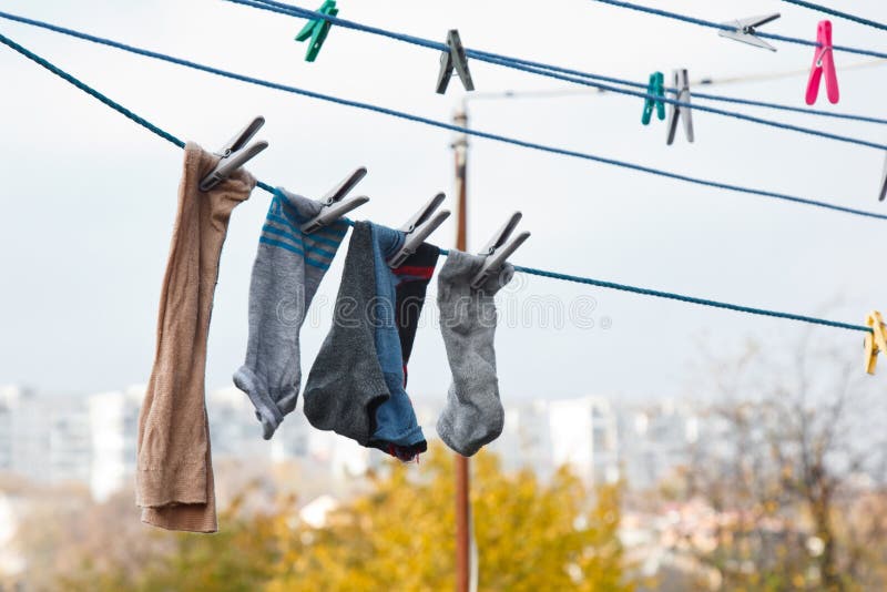 Una Abrazadera De Tela Cuelga En El Tendedero Una Cuerda Con Ropa De Cama Y  Ropa Limpia Al Aire Libre El Día De La Lavandería En Imagen de archivo -  Imagen de