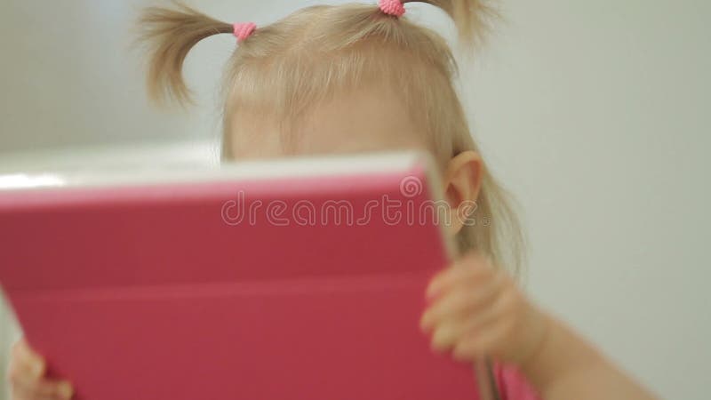 Una bambina bacia lo schermo di una compressa elettronica dopo avere visto una foto di sua madre