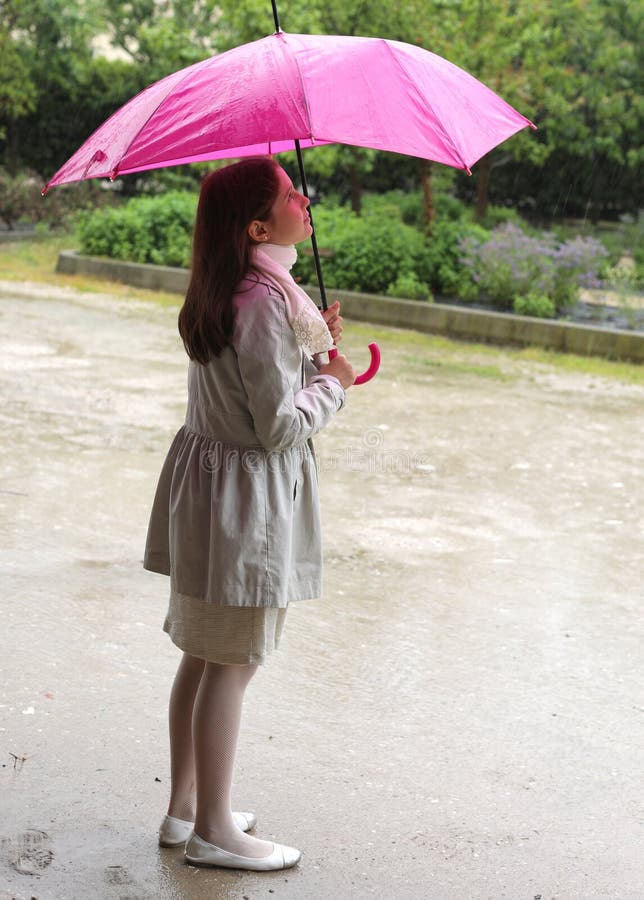 Una bambina elegante sotto la pioggia con un ombrello fotografie stock libere da diritti Una bambina elegante sotto la pioggia con un ombrello fotografie stock libere da diritti