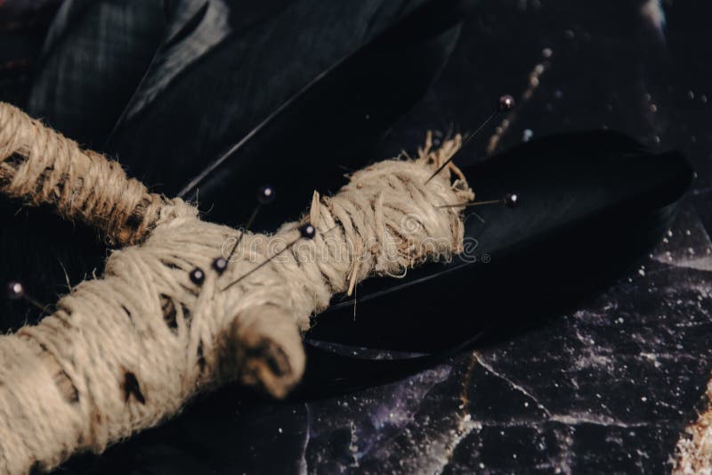 A handmade voodoo doll with pins, set against a rustic backdrop, evoking occult practices. A handmade voodoo doll with pins, set against a rustic backdrop, evoking occult practices