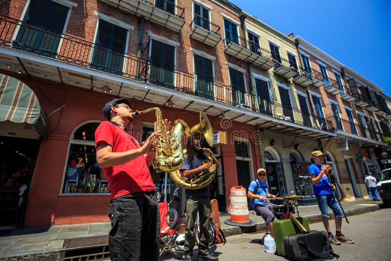 NEW ORLEANS - AUGUST 25: The French Quarter in New Orleans on August 25, 2015, a jazz band plays jazz melodies in the street for donations from the tourists. NEW ORLEANS - AUGUST 25: The French Quarter in New Orleans on August 25, 2015, a jazz band plays jazz melodies in the street for donations from the tourists