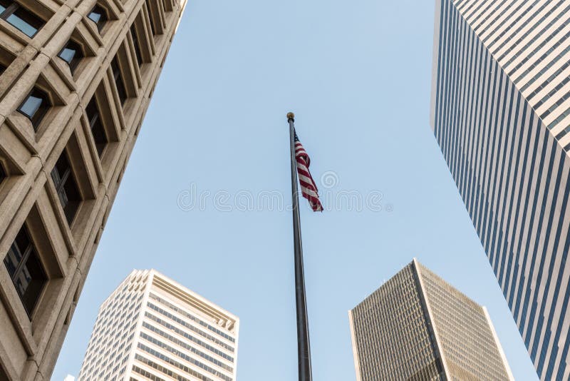 Una bandiera unita dello stato fra i grattacieli del distretto finanziario di Seattle fotografie stock libere da diritti Una bandiera unita dello stato fra i grattacieli del distretto finanziario di Seattle fotografie stock libere da diritti