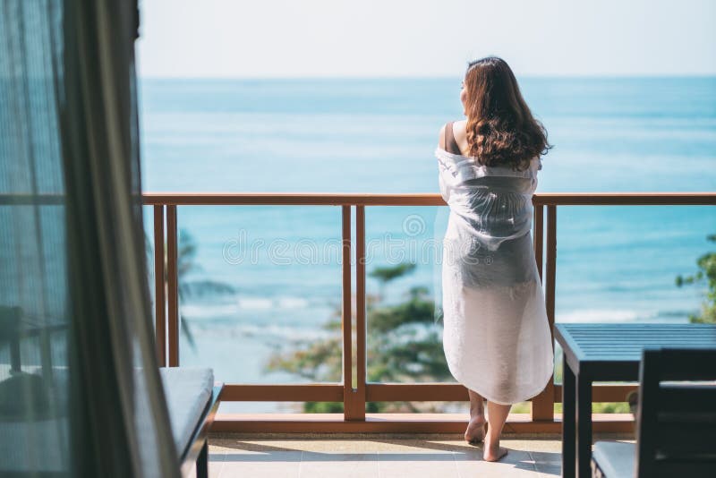 Una bella condizione asiatica della donna e godere di di guardare la vista del mare fotografia stock libera da diritti Una bella condizione asiatica della donna e godere di di guardare la vista del mare fotografia stock libera da diritti