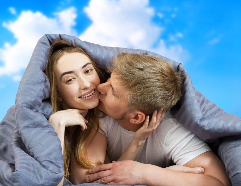Una bella coppia a letto isolata in cielo blu, restate a casa concettuale, in fondo alla quarantena per il coronavirus fotografie stock Una bella coppia a letto isolata in cielo blu, restate a casa concettuale, in fondo alla quarantena per il coronavirus fotografie stock
