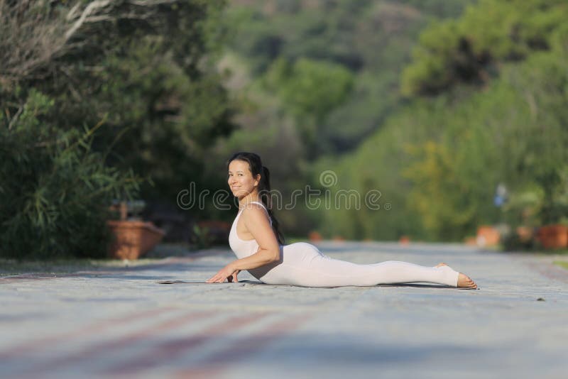 Una Bella Mujer Con Un Mono Gimnástico Blanco Se Dedica Yoga. Imagen de archivo - Imagen de libertad, hermoso: 215064631