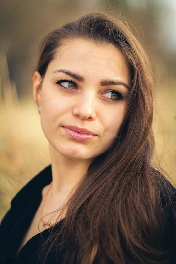 Una bella ragazza castana che posa in un campo sull'autunno Foto di arte immagine stock libera da diritti Una bella ragazza castana che posa in un campo sull'autunno Foto di arte immagine stock libera da diritti