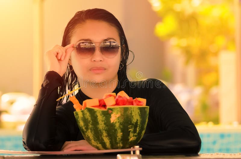 Una bella signora davanti ai frutti assortiti fotografia stock libera da diritti Una bella signora davanti ai frutti assortiti fotografia stock libera da diritti