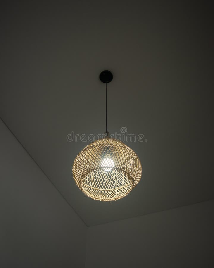 Una bellissima luce a pendenza di rattan con lampada a lampadina immagini stock libere da diritti