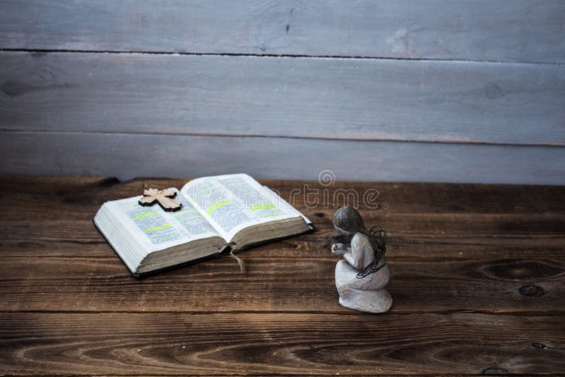 Una bibbia e un incrocio aperti di angelo fotografia stock libera da diritti Una bibbia e un incrocio aperti di angelo fotografia stock libera da diritti