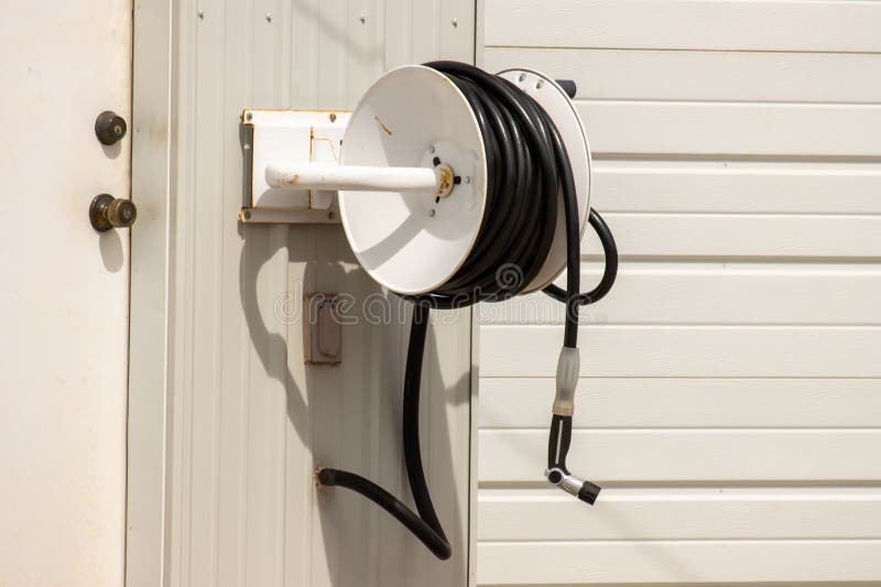 Una bobina per tubi su un garage bianco immagini stock
