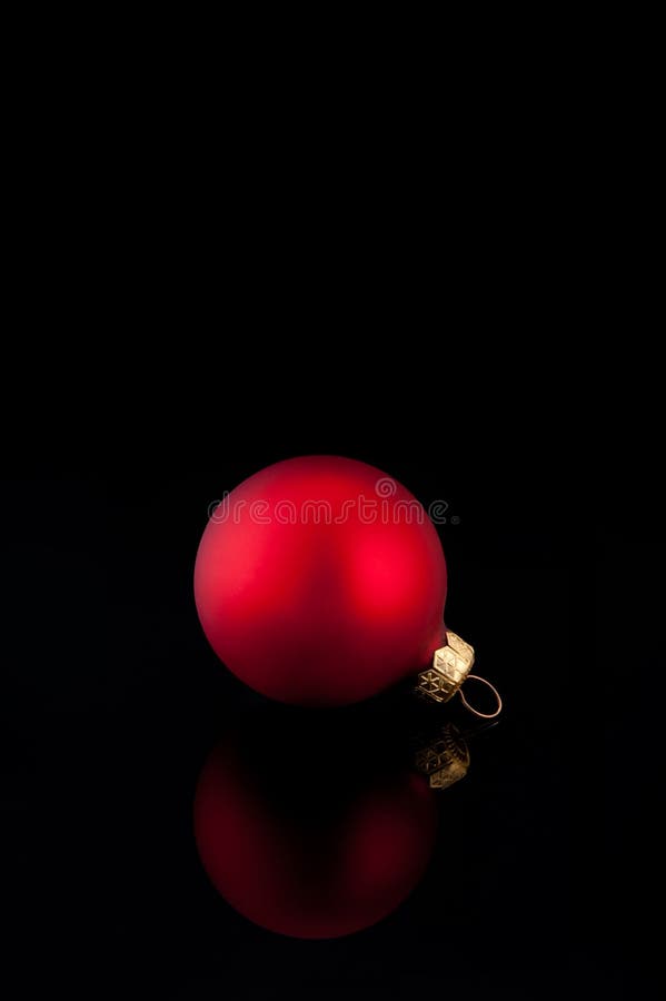 Una bola roja de la Navidad del satén en fondo negro imagenes de archivo Una bola roja de la Navidad del satén en fondo negro imagenes de archivo