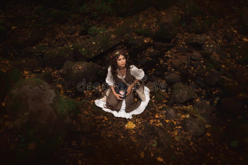 Una bruja joven en bosque fotos de archivo libres de regalías Una bruja joven en bosque fotos de archivo libres de regalías