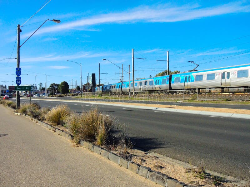 Una calle en verano con el cielo azul cerca del tren de cityrail en StKilda, Melbourne foto de archivo Una calle en verano con el cielo azul cerca del tren de cityrail en StKilda, Melbourne foto de archivo