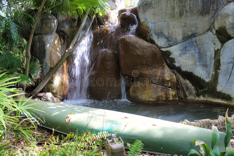 Una canoa verde embotada a lo largo del lado a la caída del agua imagen de archivo Una canoa verde embotada a lo largo del lado a la caída del agua imagen de archivo