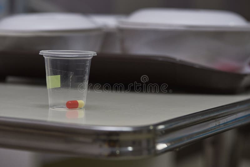 Una capsula del farmaco in tazza di plastica fotografia stock Una capsula del farmaco in tazza di plastica fotografia stock