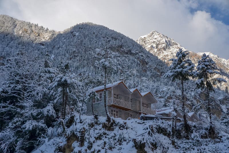 Una casa coperta di neve sulle montagne himalayane fotografia stock Una casa coperta di neve sulle montagne himalayane fotografia stock
