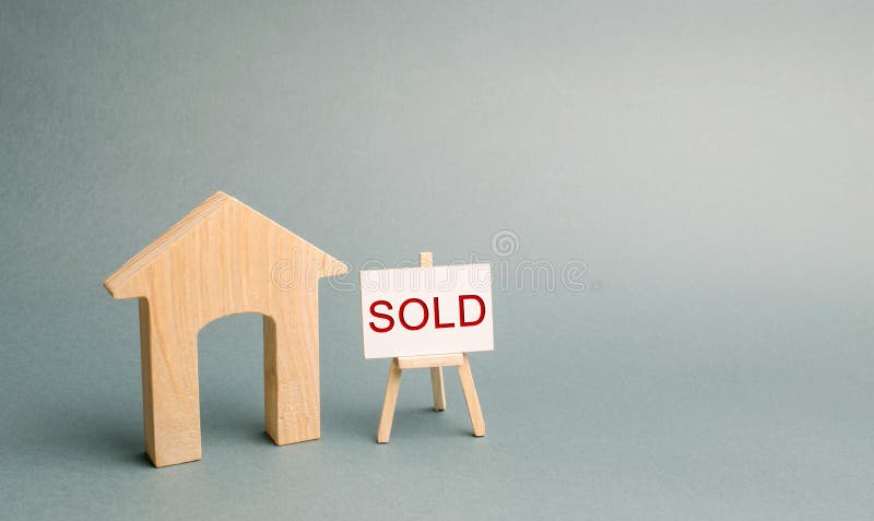 Una casa de madera miniatura y un cartel con la inscripción vendieron El concepto de vender la propiedad y las propiedades inmobi fotografía de archivo libre de regalías Una casa de madera miniatura y un cartel con la inscripción vendieron El concepto de vender la propiedad y las propiedades inmobi fotografía de archivo libre de regalías
