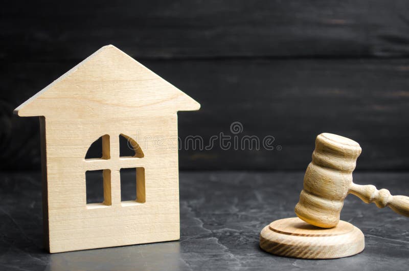 A miniature wooden house and a hammer of the judge. Auction to buy / sell a house. Forced eviction and confiscation. Clarification of ownership of property. Concept settlement of litigation. Court. A miniature wooden house and a hammer of the judge. Auction to buy / sell a house. Forced eviction and confiscation. Clarification of ownership of property. Concept settlement of litigation. Court