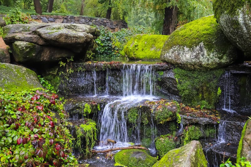Una cascada pintoresca de la cascada entre musgo grande cubrió piedras en el paisaje Sophia Park, Uman, Ucrania, otoño imágenes de archivo libres de regalías Una cascada pintoresca de la cascada entre musgo grande cubrió piedras en el paisaje Sophia Park, Uman, Ucrania, otoño imágenes de archivo libres de regalías