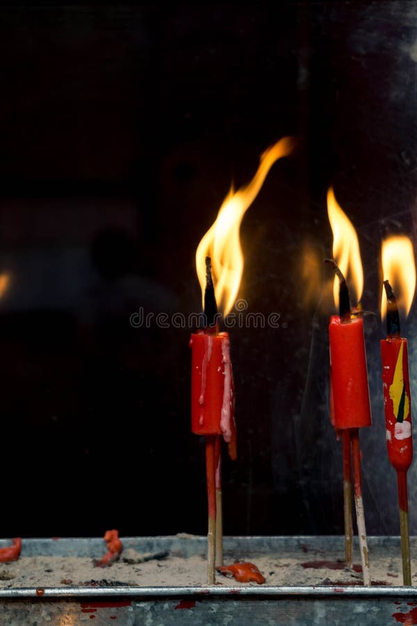 Una certa candela rossa accesa sulla sabbia immagine stock Una certa candela rossa accesa sulla sabbia immagine stock