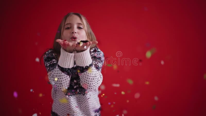 Una chica feliz con un jersey le saca a confetti de las palmas y sonríe metrajes