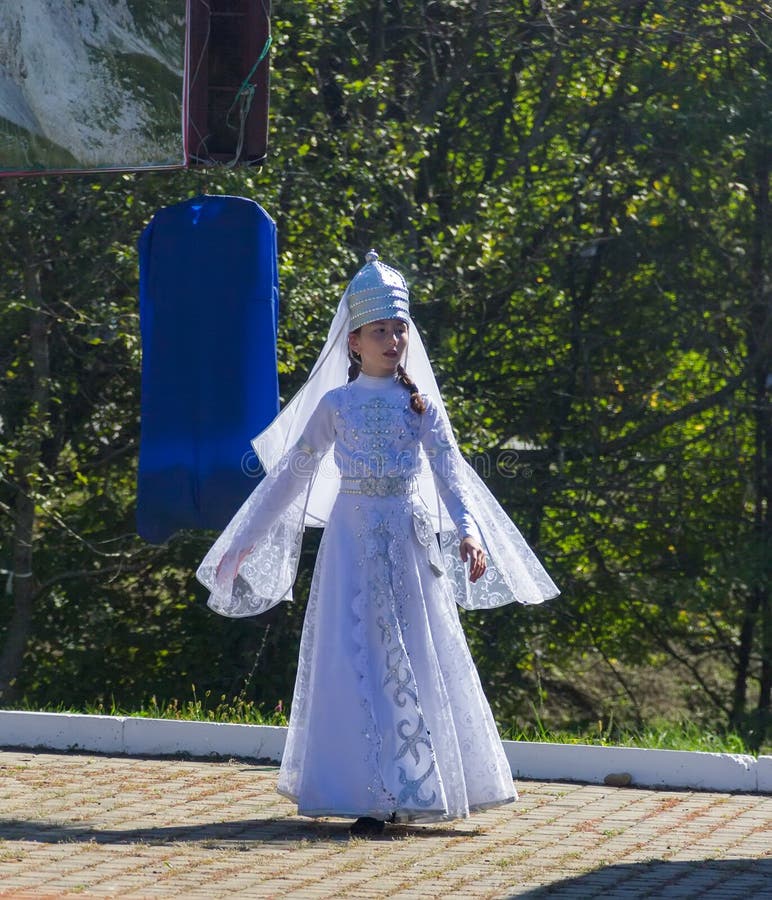 Una chica joven en la ropa del Cáucaso tradicional que baila en el festival del queso de Adyghe en las colinas del Cáucaso imágenes de archivo libres de regalías Una chica joven en la ropa del Cáucaso tradicional que baila en el festival del queso de Adyghe en las colinas del Cáucaso imágenes de archivo libres de regalías