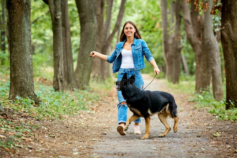 Una Chica Joven Está Caminando Con Un Perro En El Parque Foto De