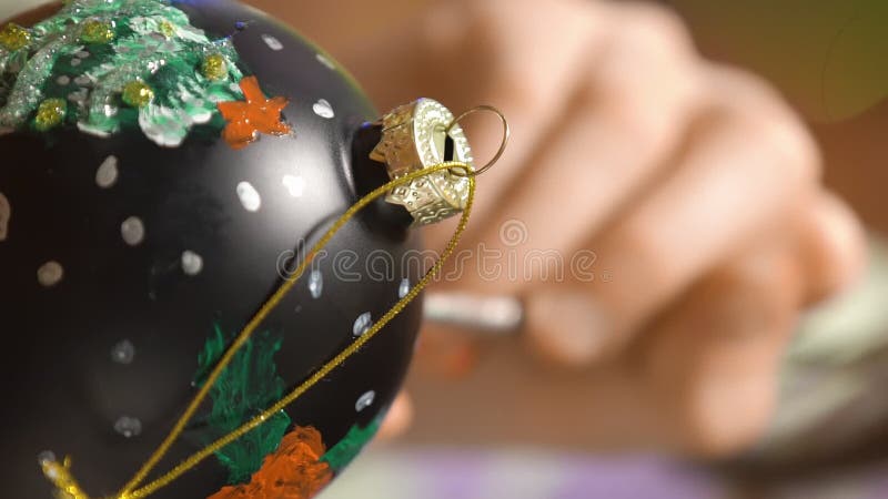 Una chica pintando decoraciones navideñas en la víspera de navidad