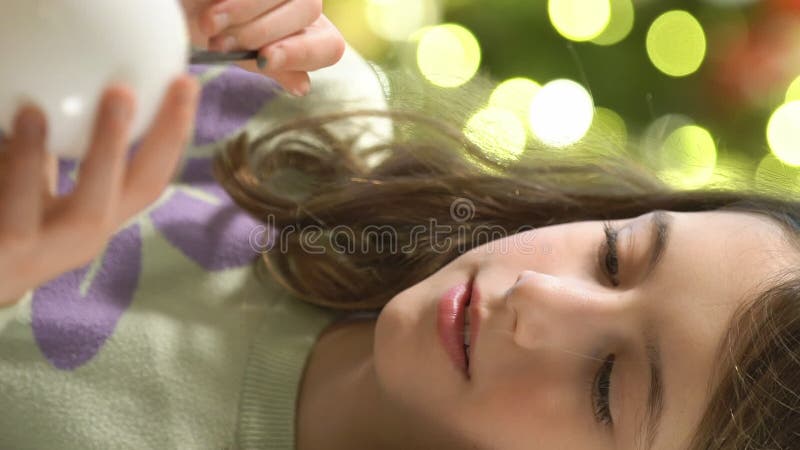 Una chica pintando decoraciones navideñas en la víspera de navidad