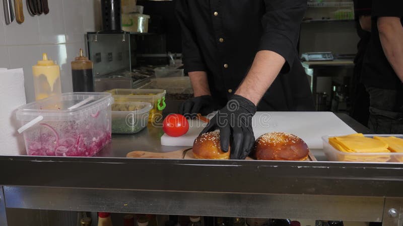 Una chiusura dello chef del ristorante prende un hamburger appena sfornato. stock footage
