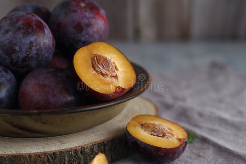 Una ciotola con prugne mature immagine stock