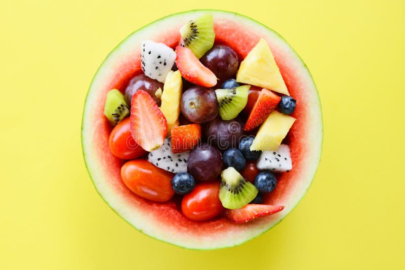 Una ciotola di frutta servita in un cocomero di cocomeri di ortaggi salubri fragole di arancio kiwi mirtilli di uva ananas pomodo immagini stock libere da diritti
