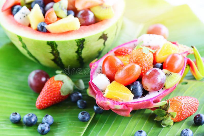 Una ciotola di frutta servita in un drago frutta e cocomeri verdure sane alimenti fragole arancioni mirtilli d'uva fotografie stock