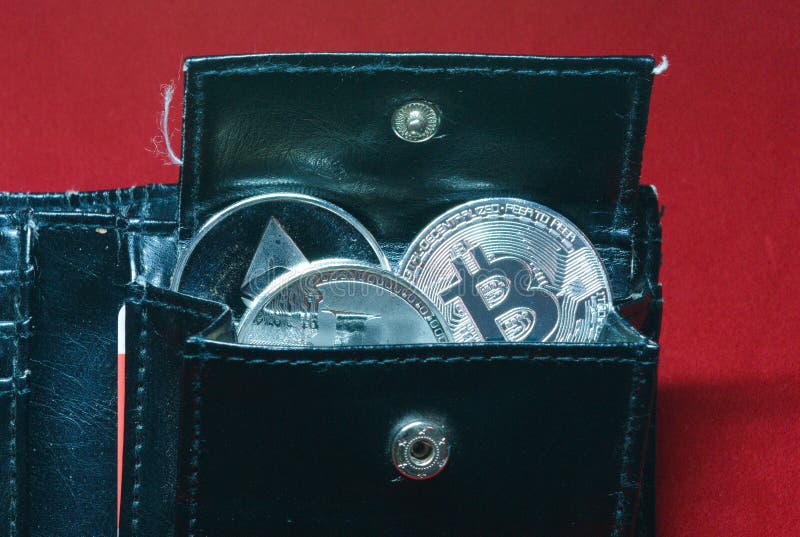 Una colección de oro y de monedas de plata del cryptocurrency en una cartera imagen de archivo libre de regalías Una colección de oro y de monedas de plata del cryptocurrency en una cartera imagen de archivo libre de regalías