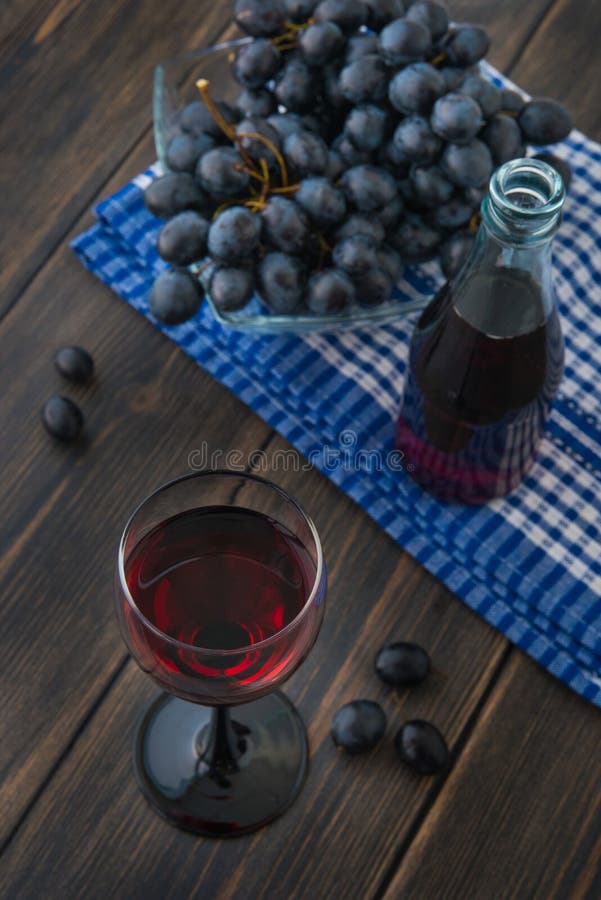 Una copa de vino fresco rojo joven con la botella de cristal y un bunc fotos de archivo