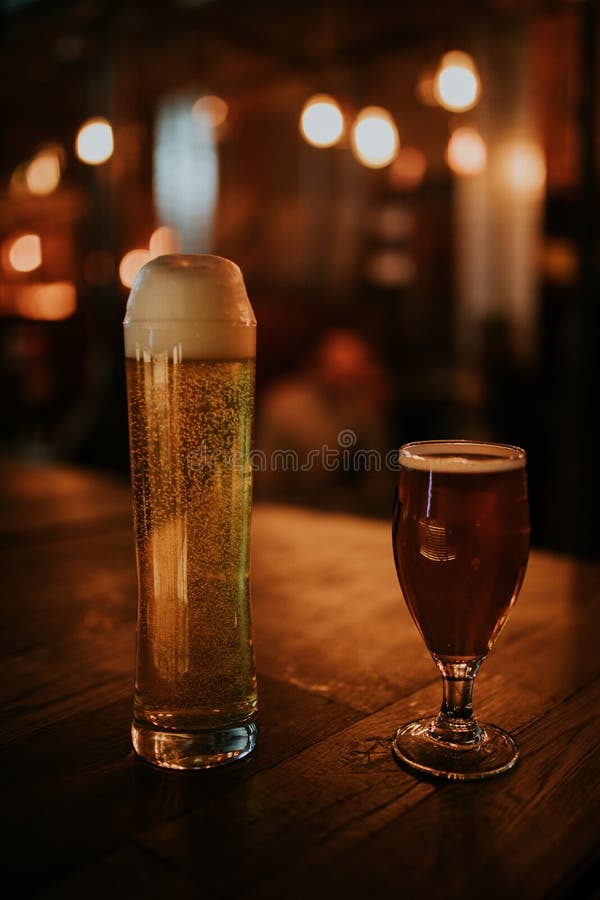 Una coppia di birre differenti su una tavola di legno immagini stock libere da diritti Una coppia di birre differenti su una tavola di legno immagini stock libere da diritti