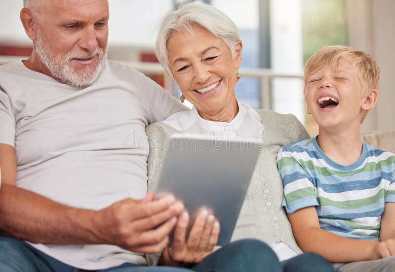 Una coppia matura felice che si unisce al proprio nipotino mentre fa la babysitter e usa un tablet digitale per una videochiamata a casa. i nonni si rilassano con il loro figlioccio carino e curiosano.