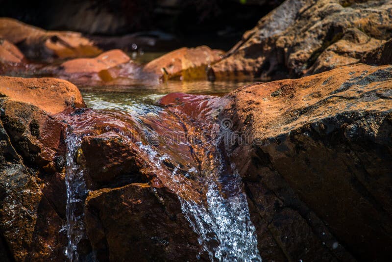 Una corrente degli scorrimenti dell'acqua giù la superficie delle pietre Shevelev fotografia stock libera da diritti Una corrente degli scorrimenti dell'acqua giù la superficie delle pietre Shevelev fotografia stock libera da diritti