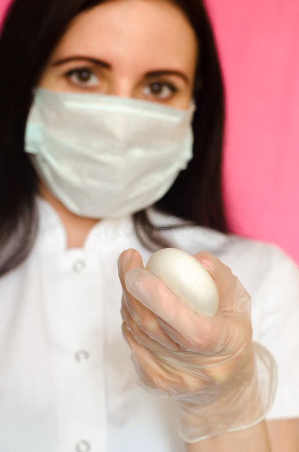 Una doctora sostiene un jabón y lleva una máscara médica. prevención de diferentes enfermedades virales incluyendo covid19 foto de archivo