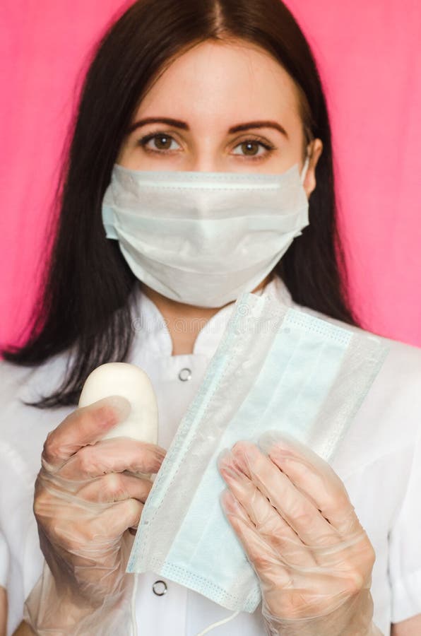 Una doctora sostiene un pedazo de jabón y una máscara médica. prevención de diferentes enfermedades virales incluyendo covid19 foto de archivo libre de regalías
