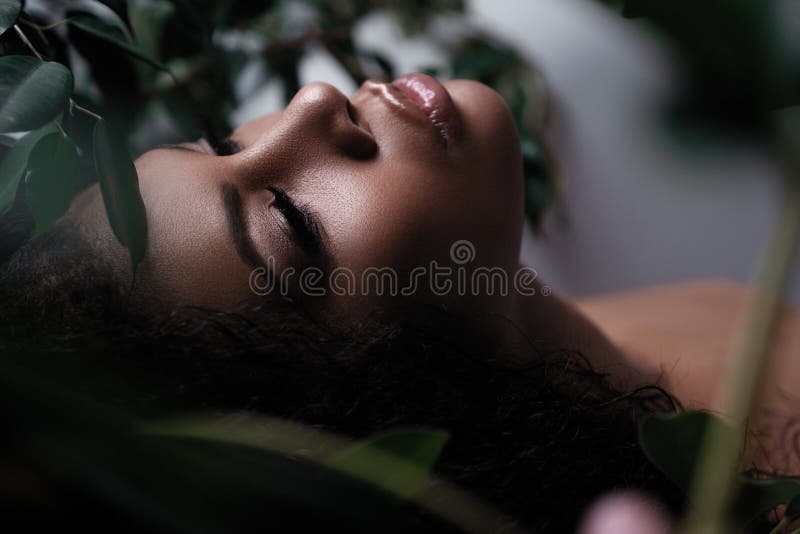 Una donna afroamericana con trucco fresco sul suo fronte Vegetazione e bellezza