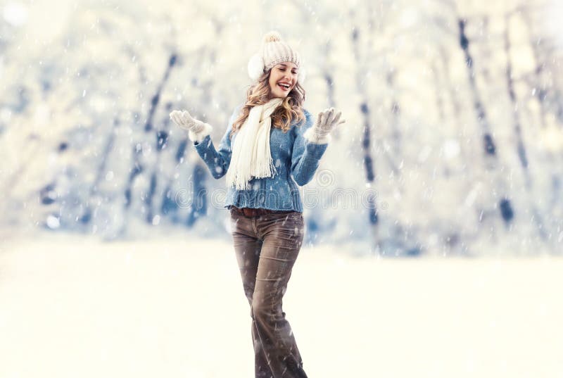 Una donna allegra e gioiosa che abbraccia la bellezza di una nevicata invernale. braccia aperte mentre il suo volto brilla di feli immagine stock libera da diritti