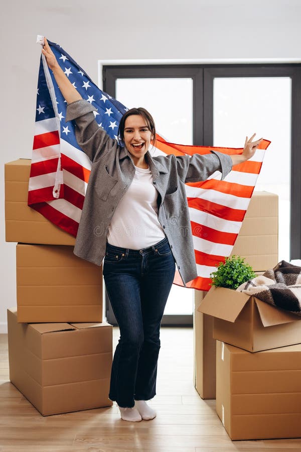 An American woman moved to a new house. Dancing with the US flag. An American woman moved to a new house. Dancing with the US flag.