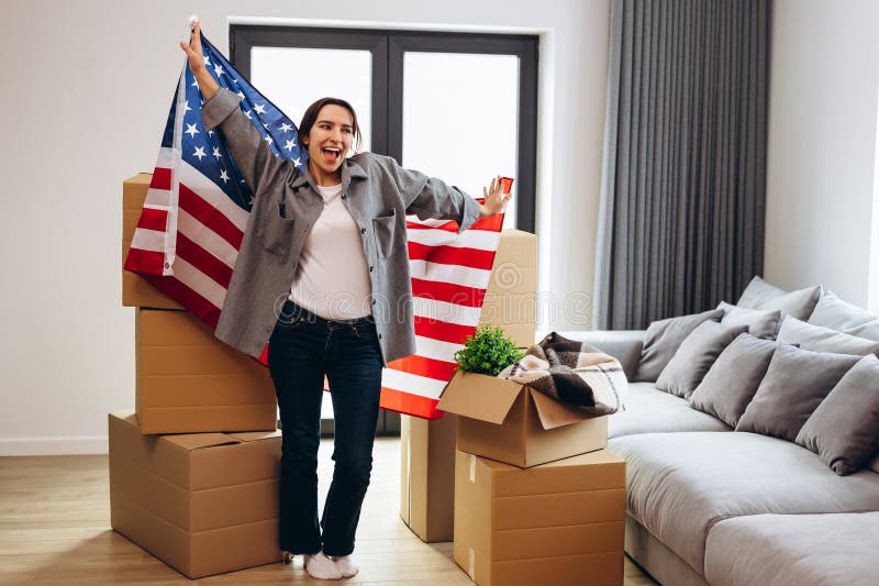 An American woman moved to a new house. Dancing with the US flag. An American woman moved to a new house. Dancing with the US flag.